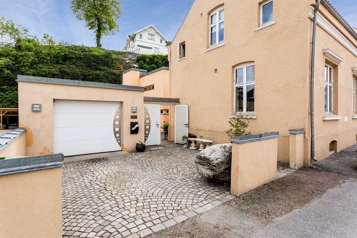 Frittstående garasje med parkering i front av boligen. Galleribilde