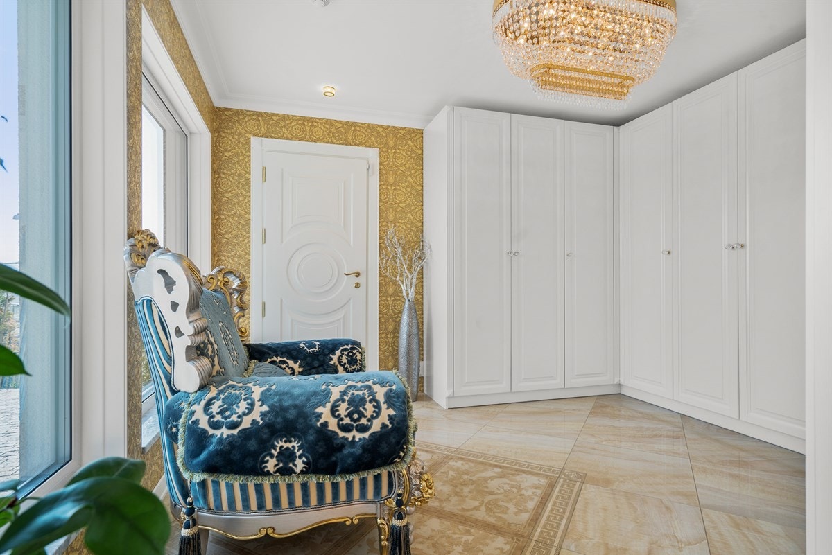 PROAKTIV Eiendomsmegling - Videre fordeler hallen også til et garderoberom på hele 14 kvm. Rommet er innredet med hvite, profilerte garderobeskap, som gjennom den ene døren, gir tilgang til et romslig bodrom på 13 kvm samt direkte utgang til garasjen. Galleribilde