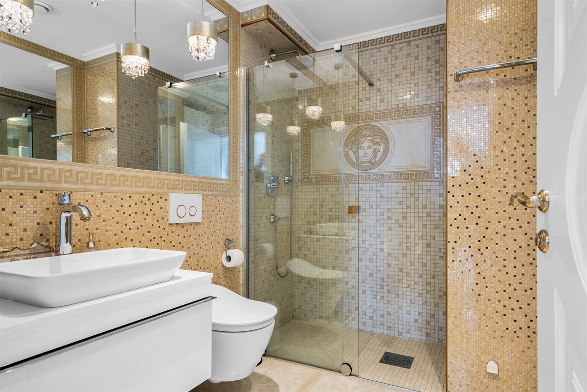 PROAKTIV Eiendomsmegling - Hvert av baderommene er innredet i ulike Versace-stiler med flis på vegger og gulv, innredning og sanitæutstyr fra Villeroy & Boch, servant- og dusjarmatur fra Grohe. Galleribilde