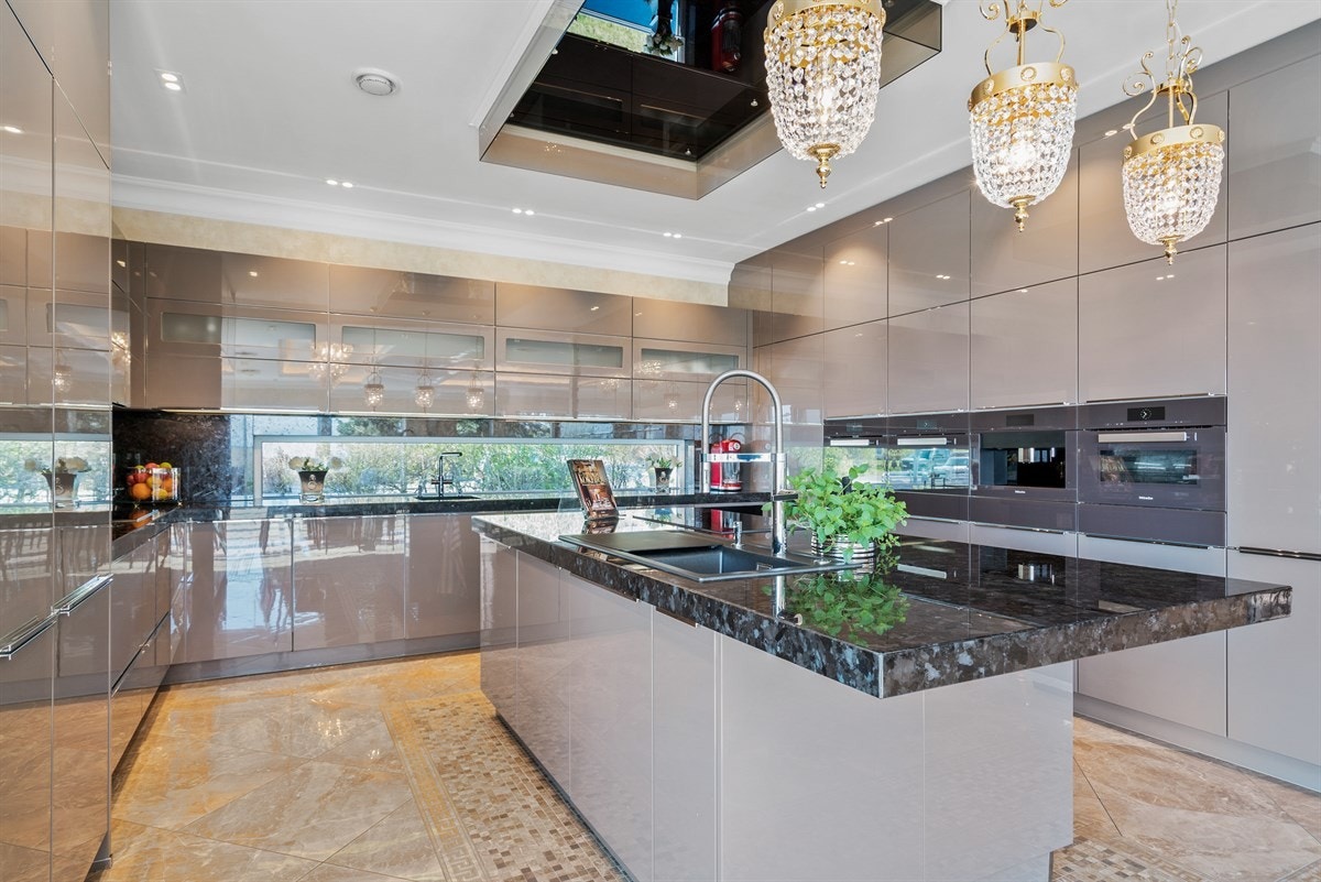 PROAKTIVEiendomsmegling - I benkeplaten over kjøkkenøyen, er det nedfelt en Blanco-vask, armatur fra Grohe og induksjonstopp. Over stekesonen er det montert en kraftig vifte inspirert av Sverre Moe. Galleribilde