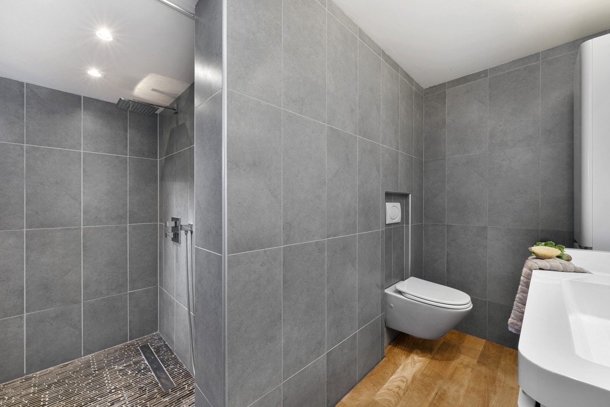 Den stilige innredningen består av dobbel servant på hvitt servantmøblement. Galleribilde