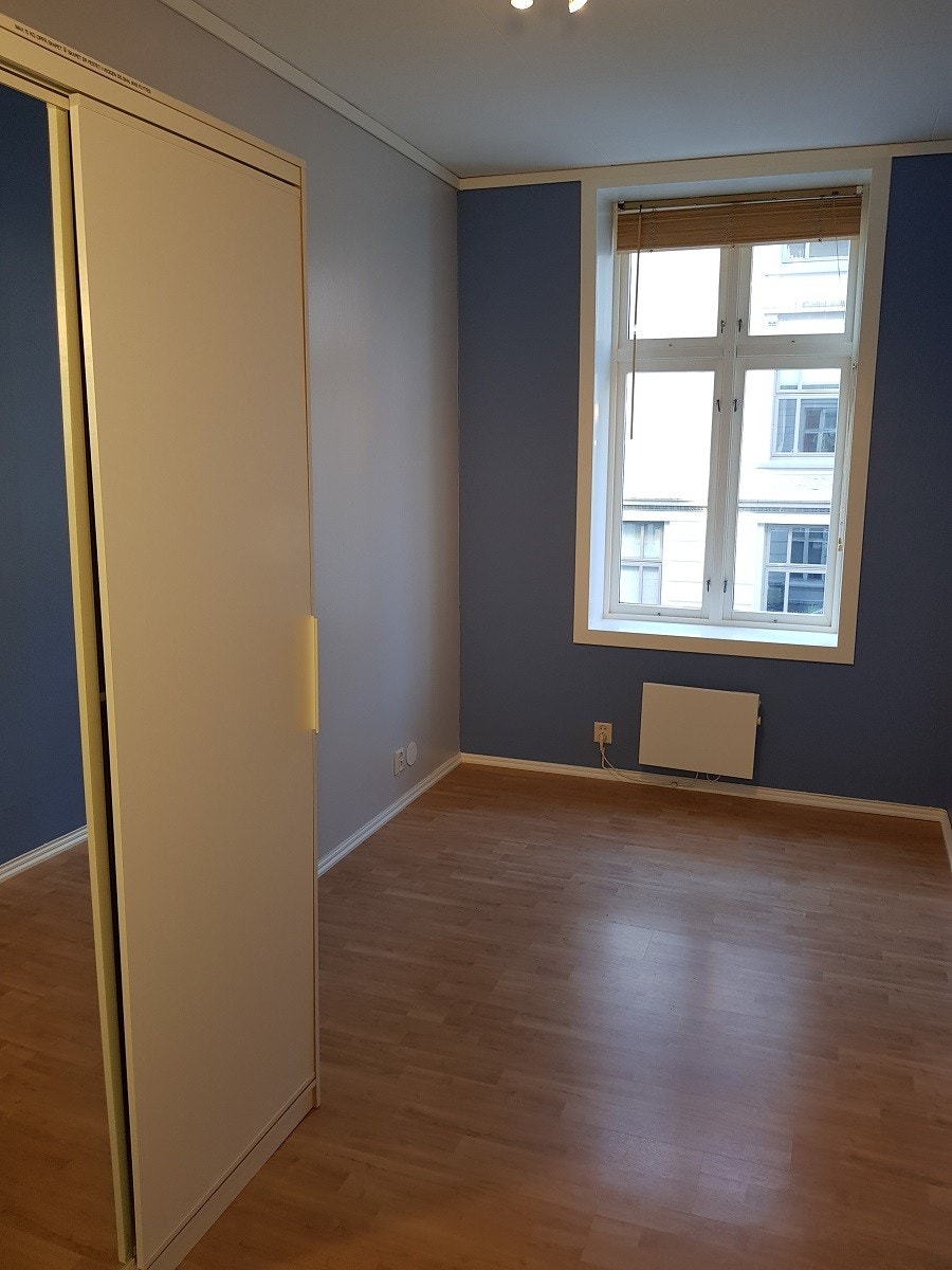 Soverom 1: Garderobeskap med speil til venstre, vindu ut mot rolig gate Galleribilde