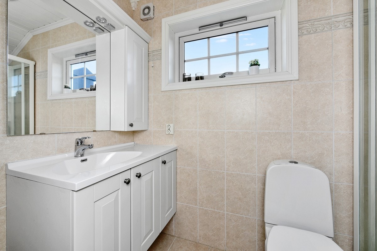 Badet i 3. etasje har flislagte overflater i lyse sandtoner med varme i gulv. Galleribilde