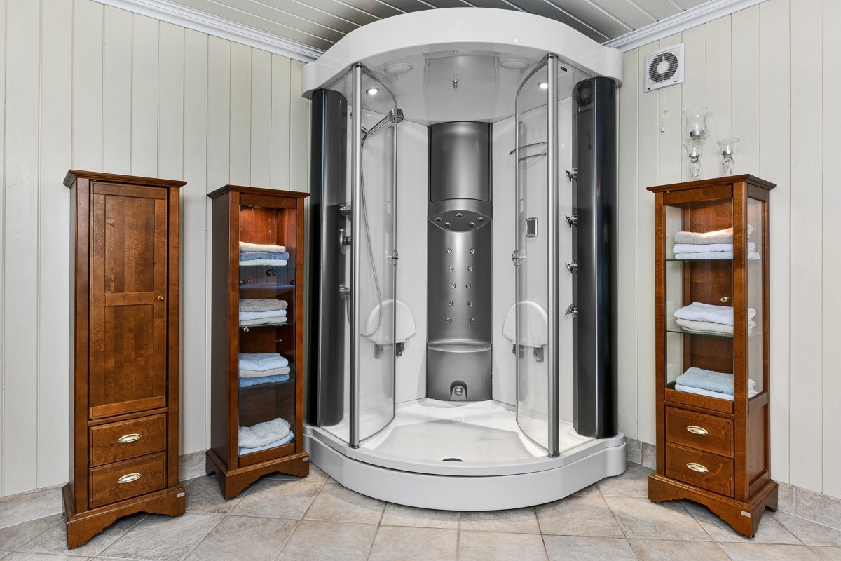 Badet er utstyrt med vegghengt toalett og et romslig steamdusj-kabinett. Galleribilde