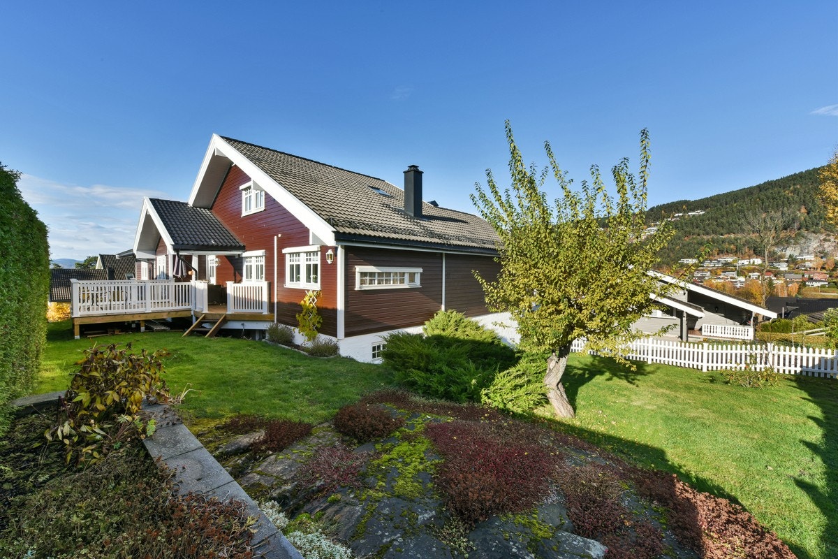 Tomten er opparbeidet med gressplen, prydbusker og blomsterbed. Galleribilde