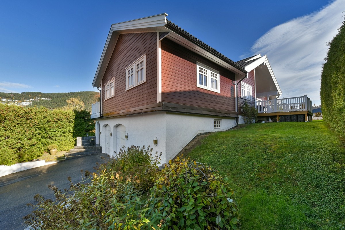 Tomten er opparbeidet med gressplen, prydbusker og blomsterbed. Galleribilde