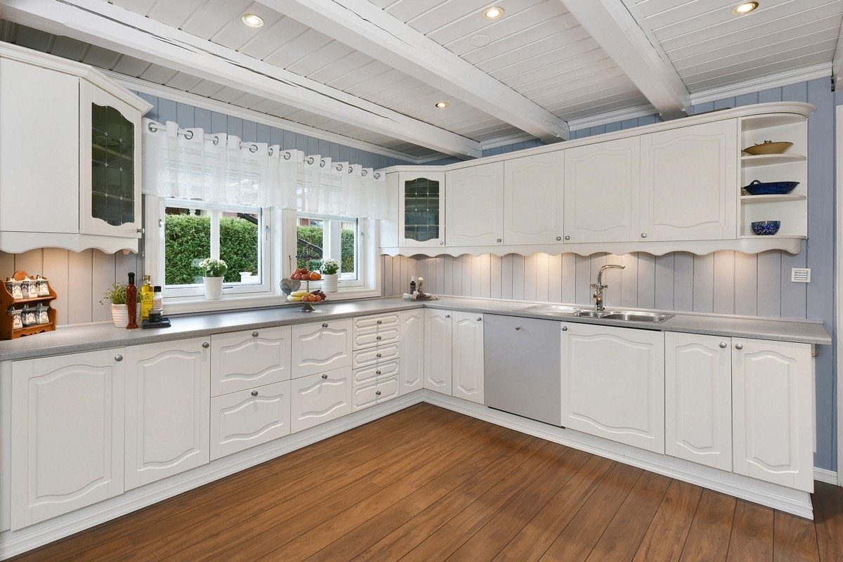 Kjøkkeninnredningen har kremhvite, profilerte fronter og nyere laminerte benkeplater. Galleribilde