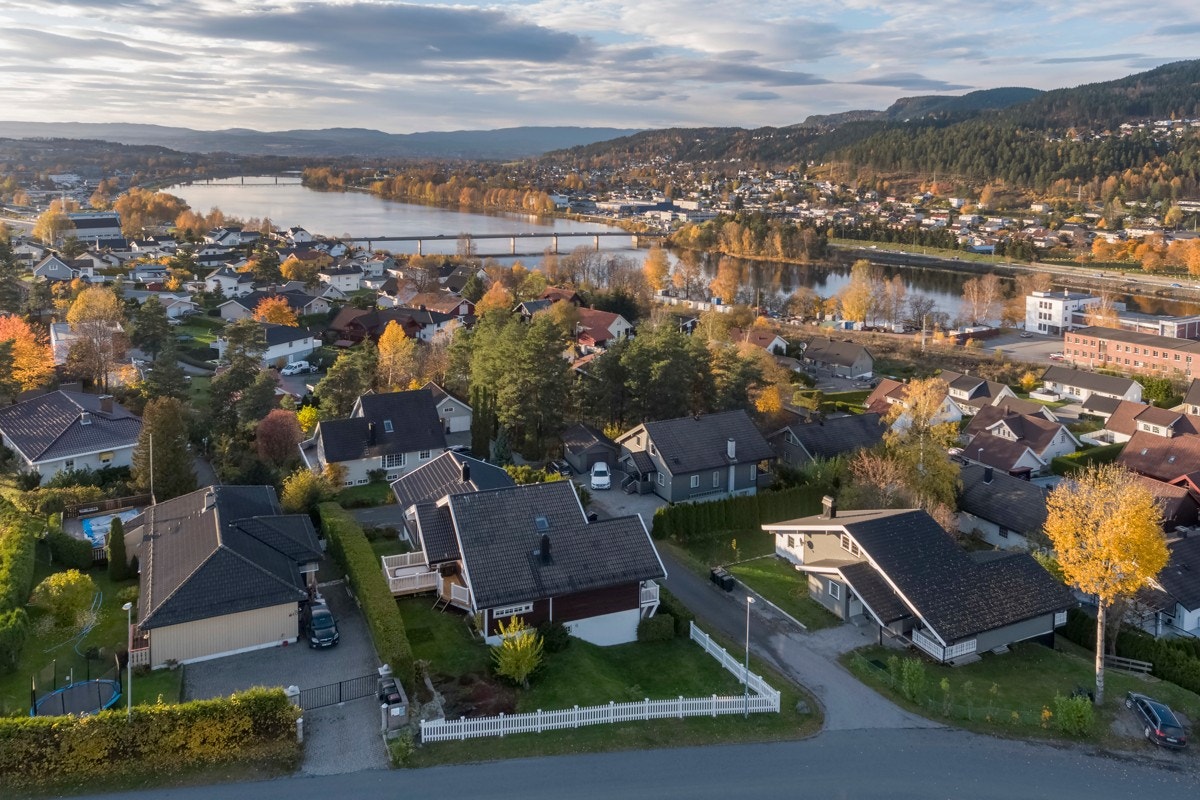 Tomten er skrånende over flere nivå, og omkranset av hvitt stakittgjerde. Galleribilde