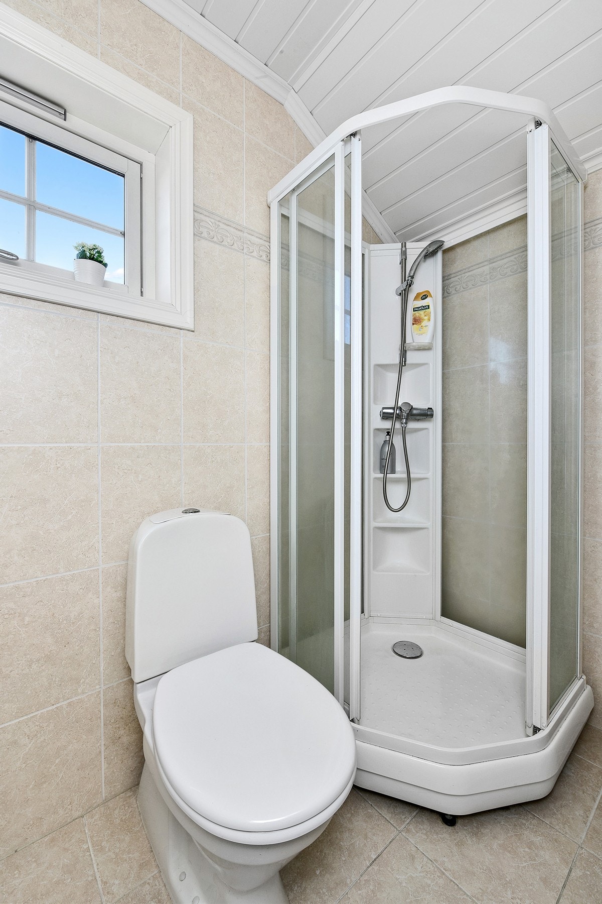 Badet er innredet med en heldekkende servant, toalett og dusjkabinett. Galleribilde