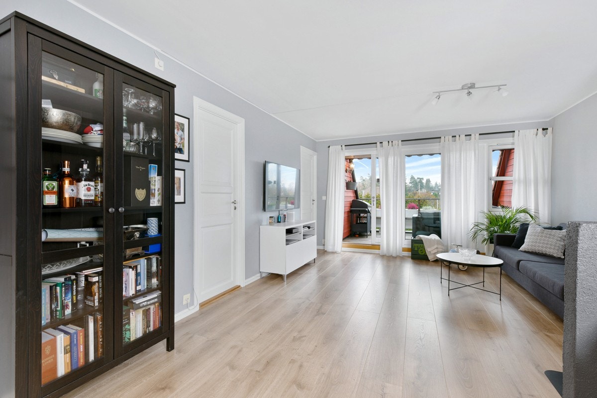 Mot terrassen strømmer dagslyset inn fra vindu og en dobbel skyvedør. Galleribilde