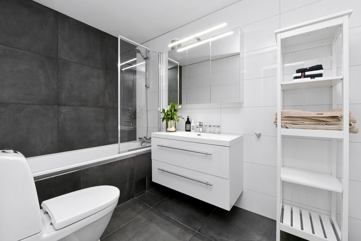 Badet ble oppgradert i 2018. Rommet er romslig og delikat, med store, grå fliser på gulvet, badekarsfronten og på vegg bak badekaret. Galleribilde