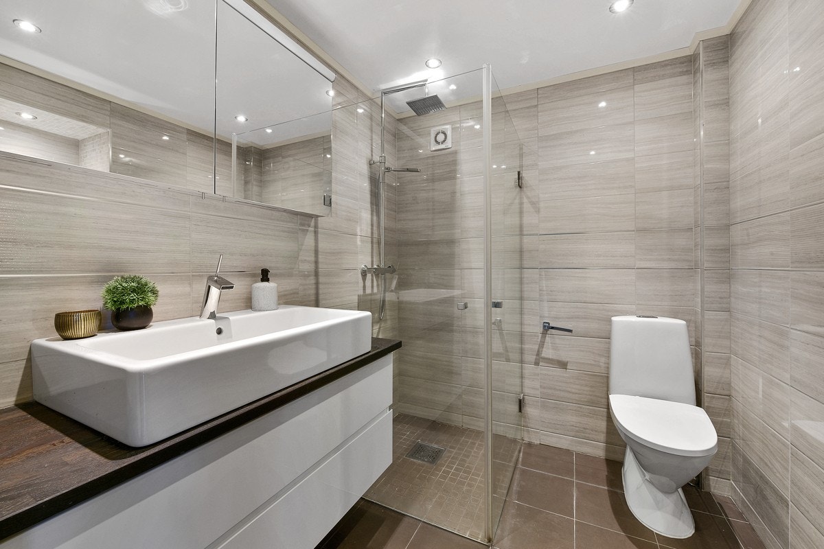 Badet har et dusjhjørne med regnfallsdusj, hånddusj og innfellbare glassdører. Galleribilde