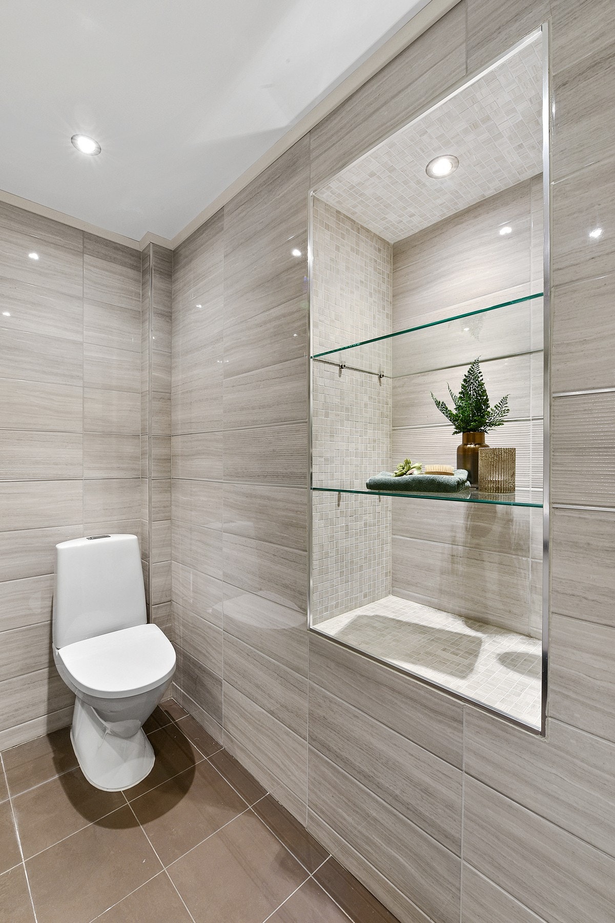 En nisje med glasshyller og lys. Galleribilde