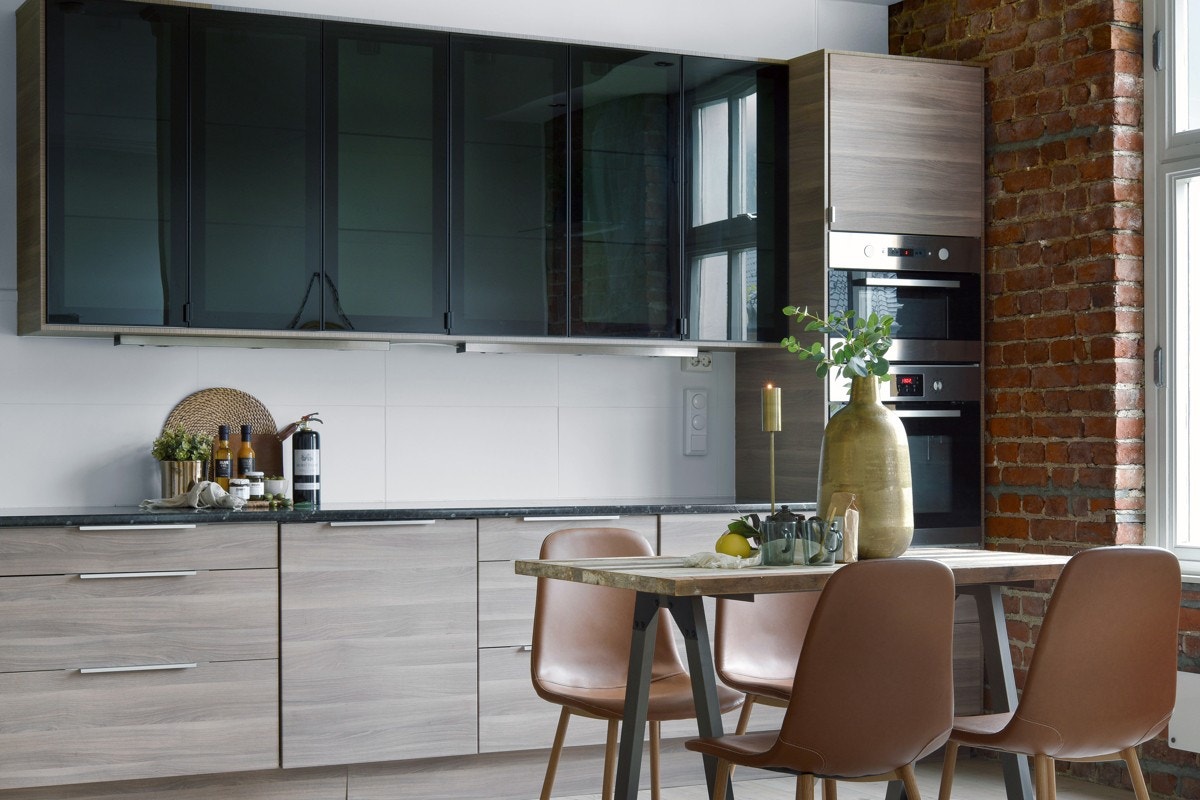 Kjøkkeninnredningen har en stilig kombinasjon av mørke vitrineskap og fronter i trestil. Galleribilde