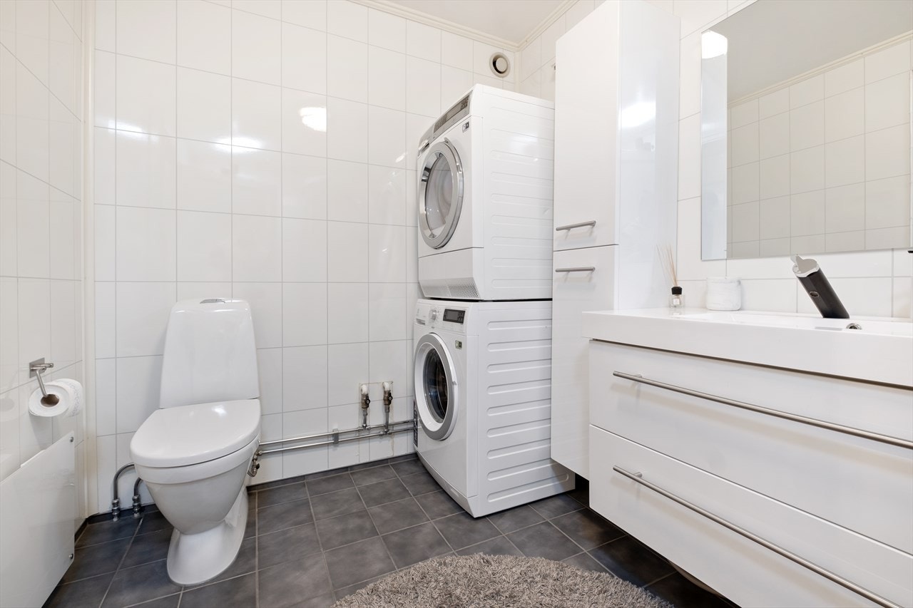 Badet har flislagt gulv og baderomsplater med flismønster på veggene, hvor overflatene er fra 2013. Galleribilde