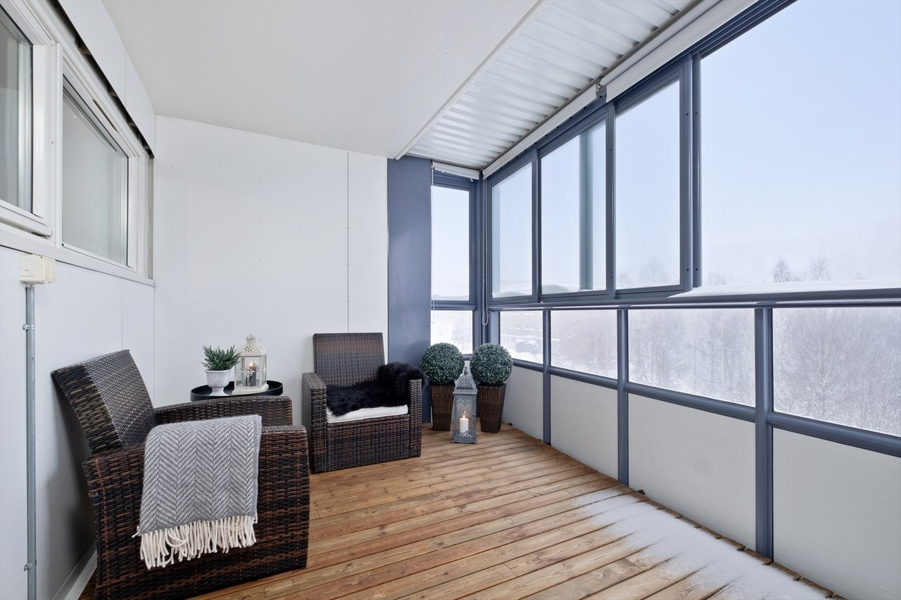 Den innglassede balkongen måler ca. 8 kvm, har terrassebord i treverk og skyvbare glassvinduer. Galleribilde