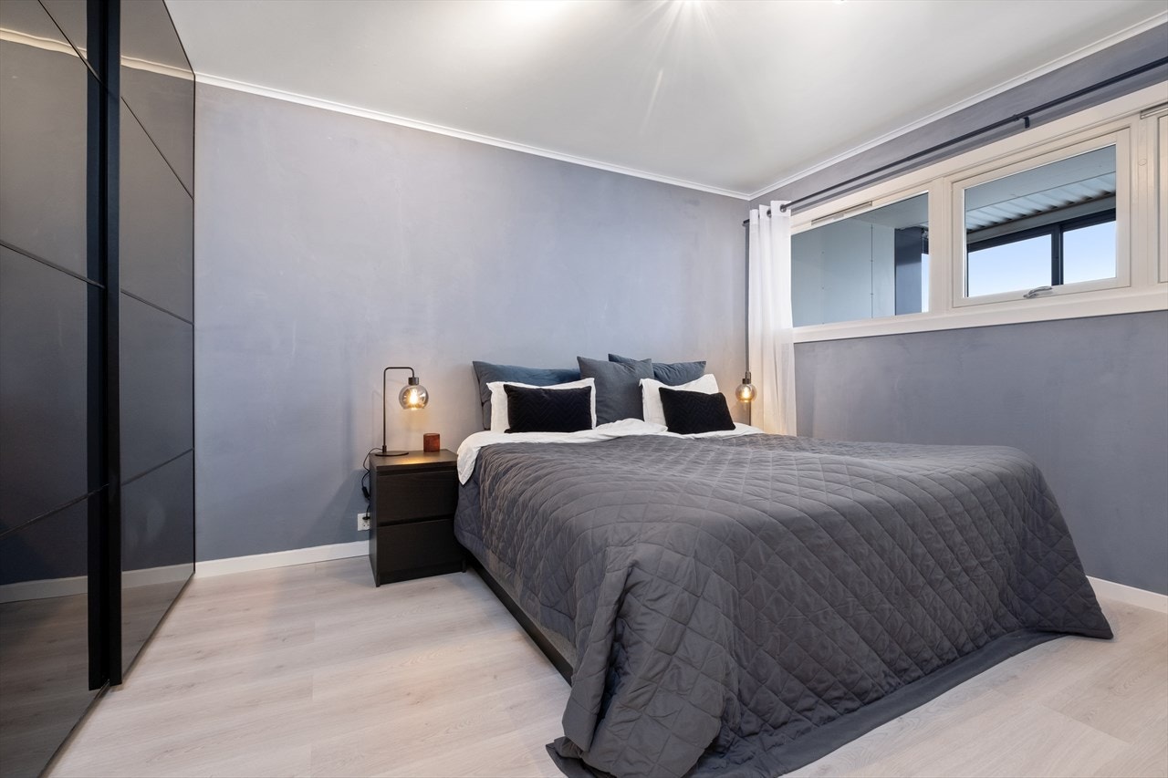 Rommet er utstyrt med en skyvedørsgarderobe med stilige mørke fronter. Galleribilde