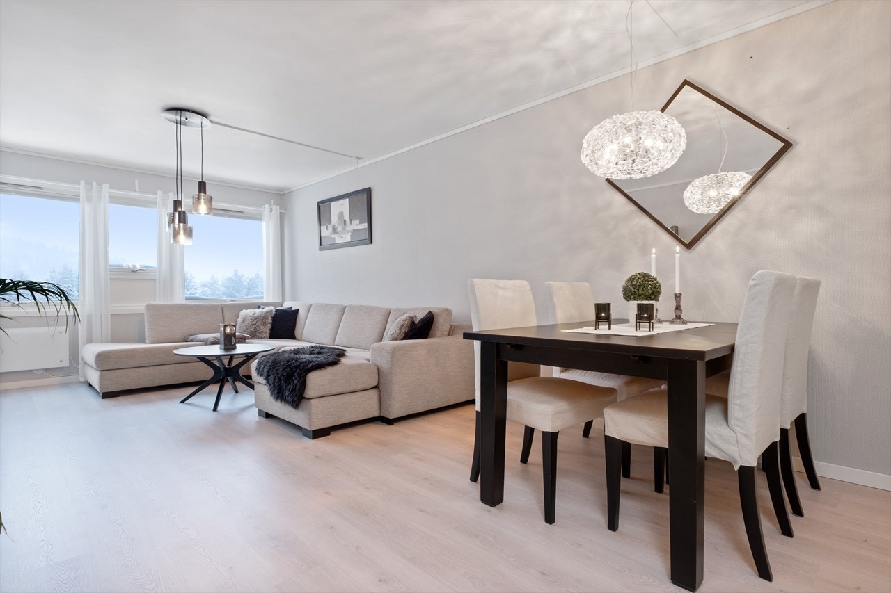 Stuen har laminat på gulvet, lysmalte vegger og store vindusflater. Galleribilde