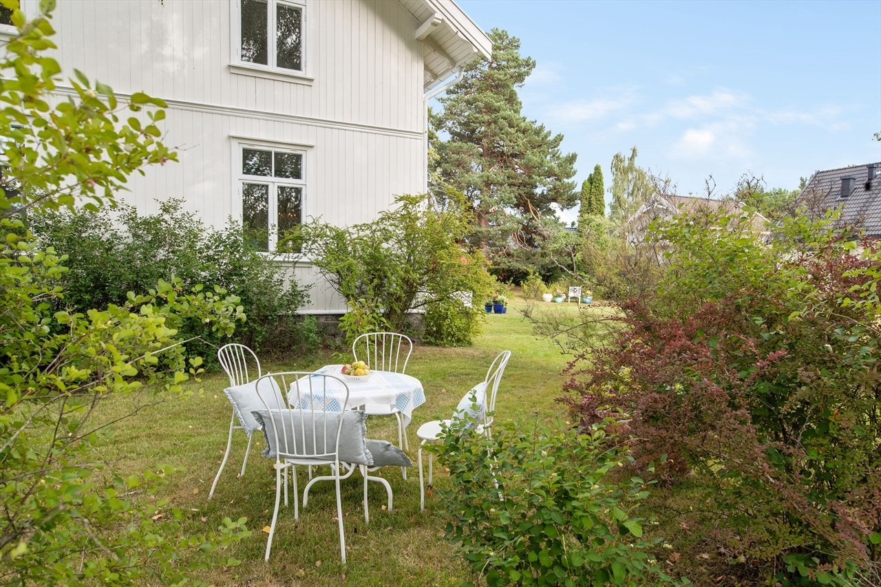 Hagen er usjenert, bak frodige trær. Galleribilde