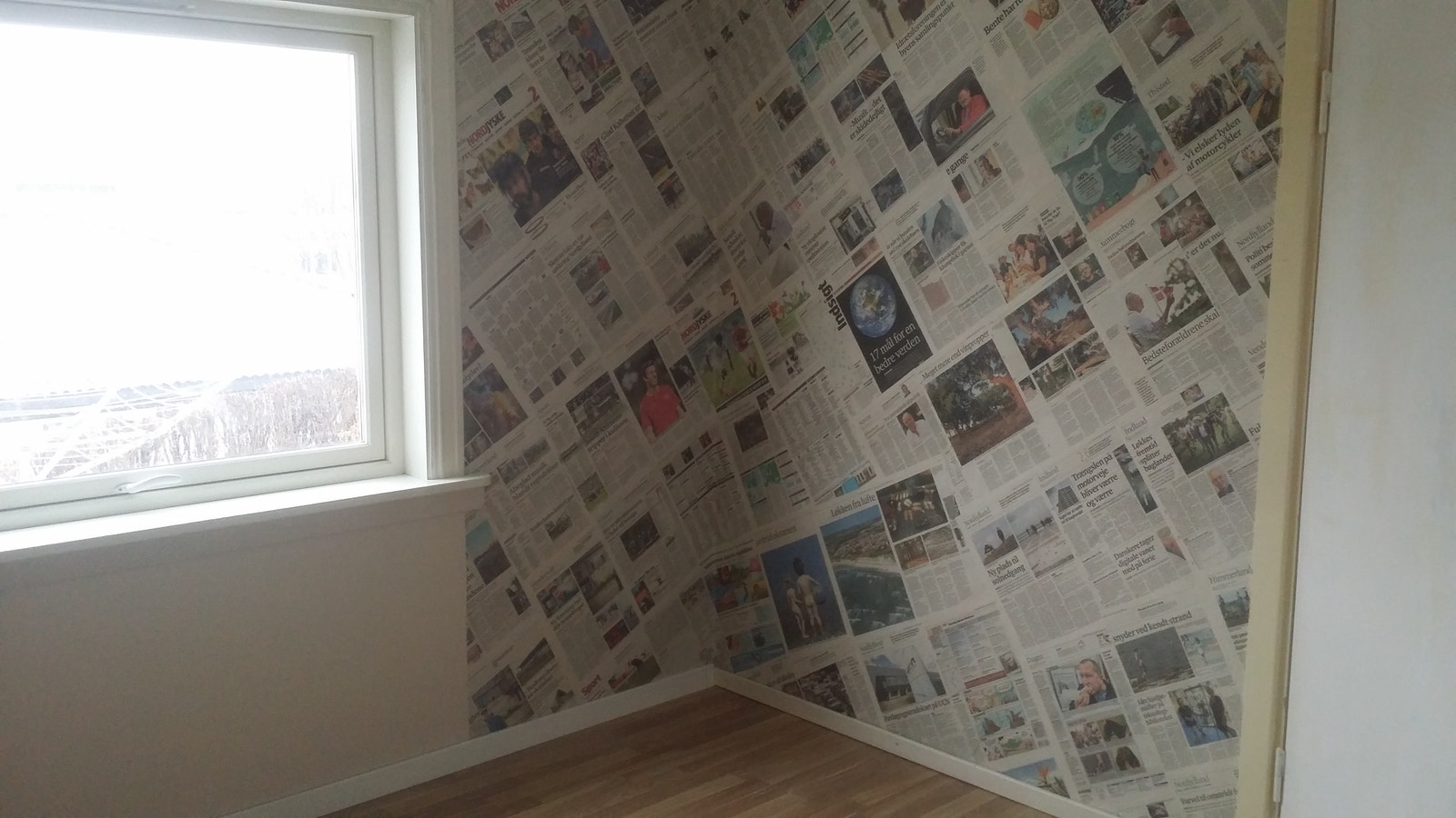 ene soverommet er dekorert med danske aviser i et hjørne Galleribilde