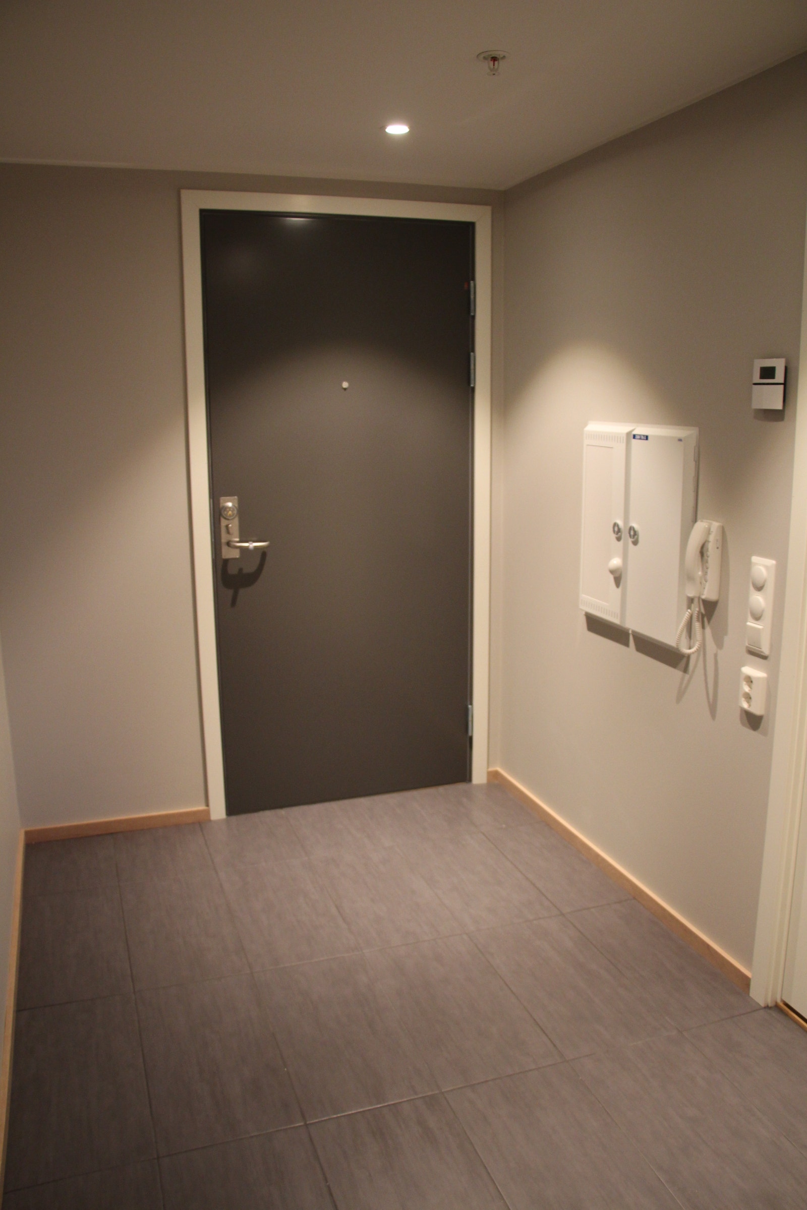 Entré med flislagt gulv. Porttelefon og sikringsskap. Galleribilde