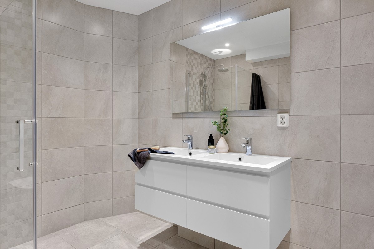 Badet er innredet med dobbel servant, dusj nisje, vegghengt servant. Galleribilde
