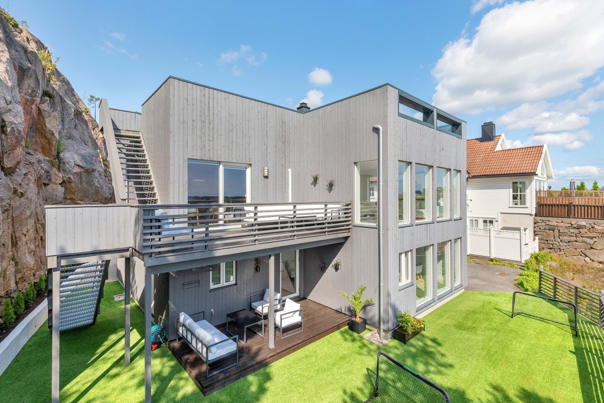 Solrik uteområde med kunstgress og platting Galleribilde