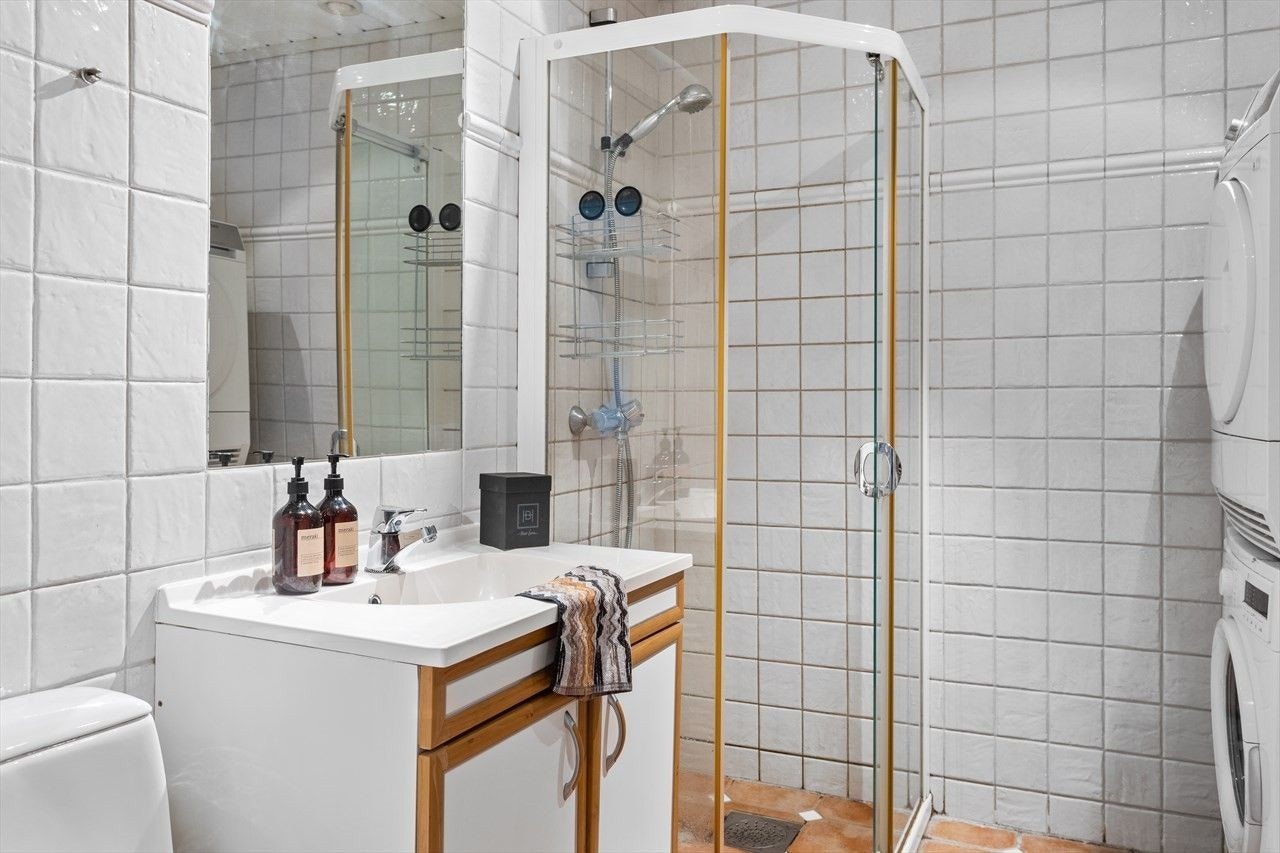 Badet er innredet med en enkel servant, praktisk speilskap med overliggende belysning. Galleribilde