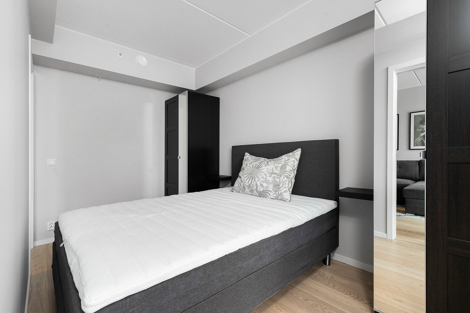 Lyst soverom med dobbeltseng og garderobeskap på begge sider. Galleribilde