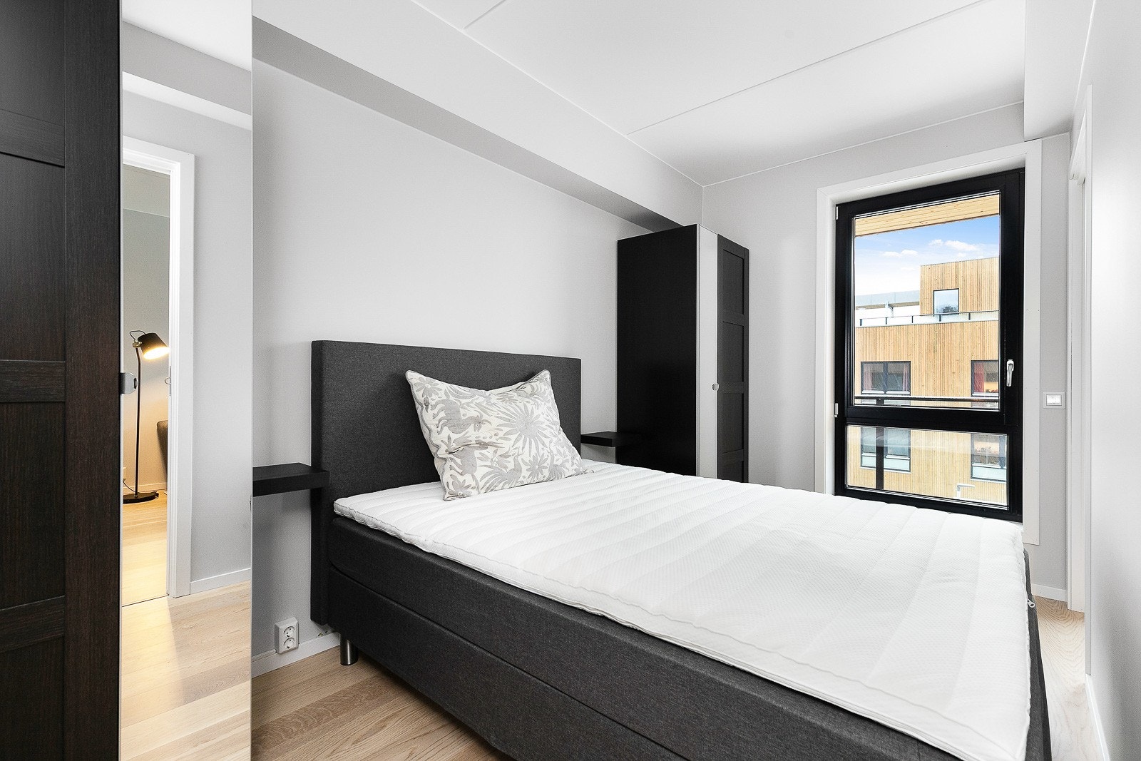 Lyst soverom med dobbeltseng og garderobeskap på begge sider. Galleribilde