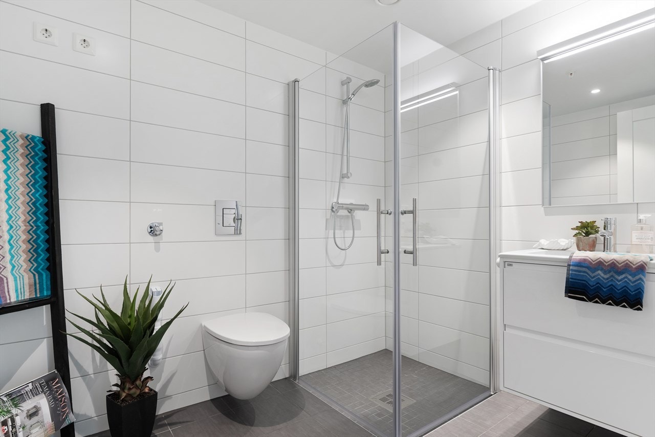 Delikat bad med gulvvarme, stort dusjhjørne, opplegg for vaskemaskin og downlights i taket Galleribilde