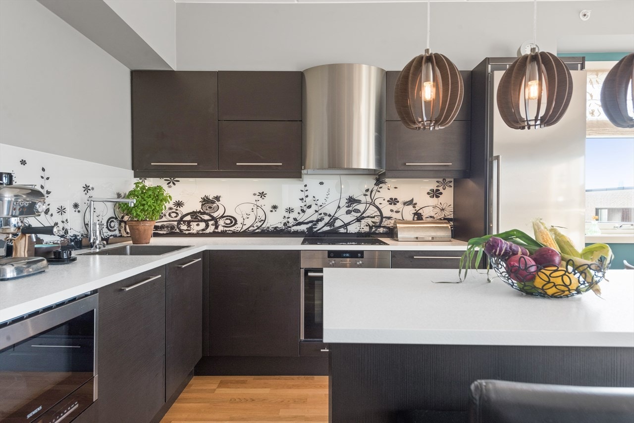 Det er montert plate i designglass mellom over- og underskap. Galleribilde