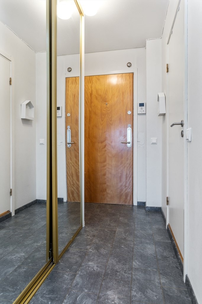 Lys gang med oppbevaring i skyvedørsgarderobe med speilfronter. Galleribilde