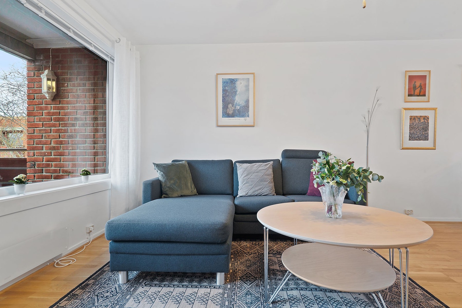 Stue med parkettbelagt gulv og lyse vegg/-takflater Galleribilde