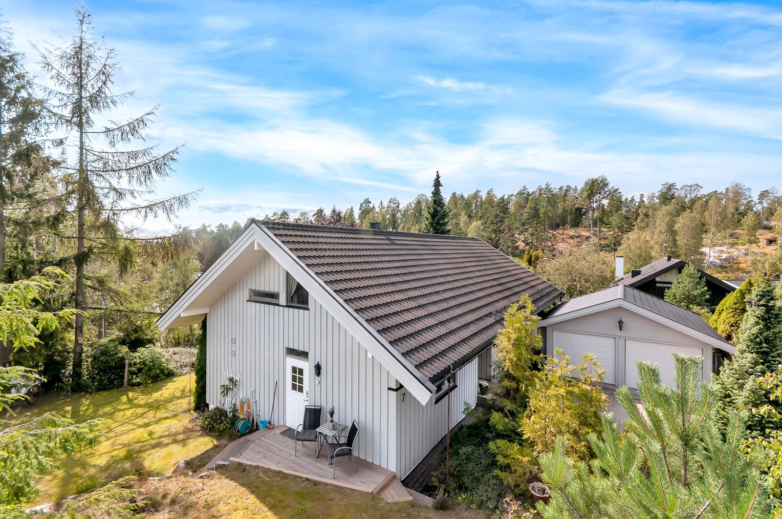 Fasade og hage. Terrasseplatting ved kjøkkeninngangen. Galleribilde