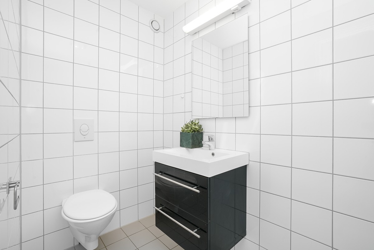 Badet er utstyrt med vegghengt toalett og dusjhjørne. Galleribilde