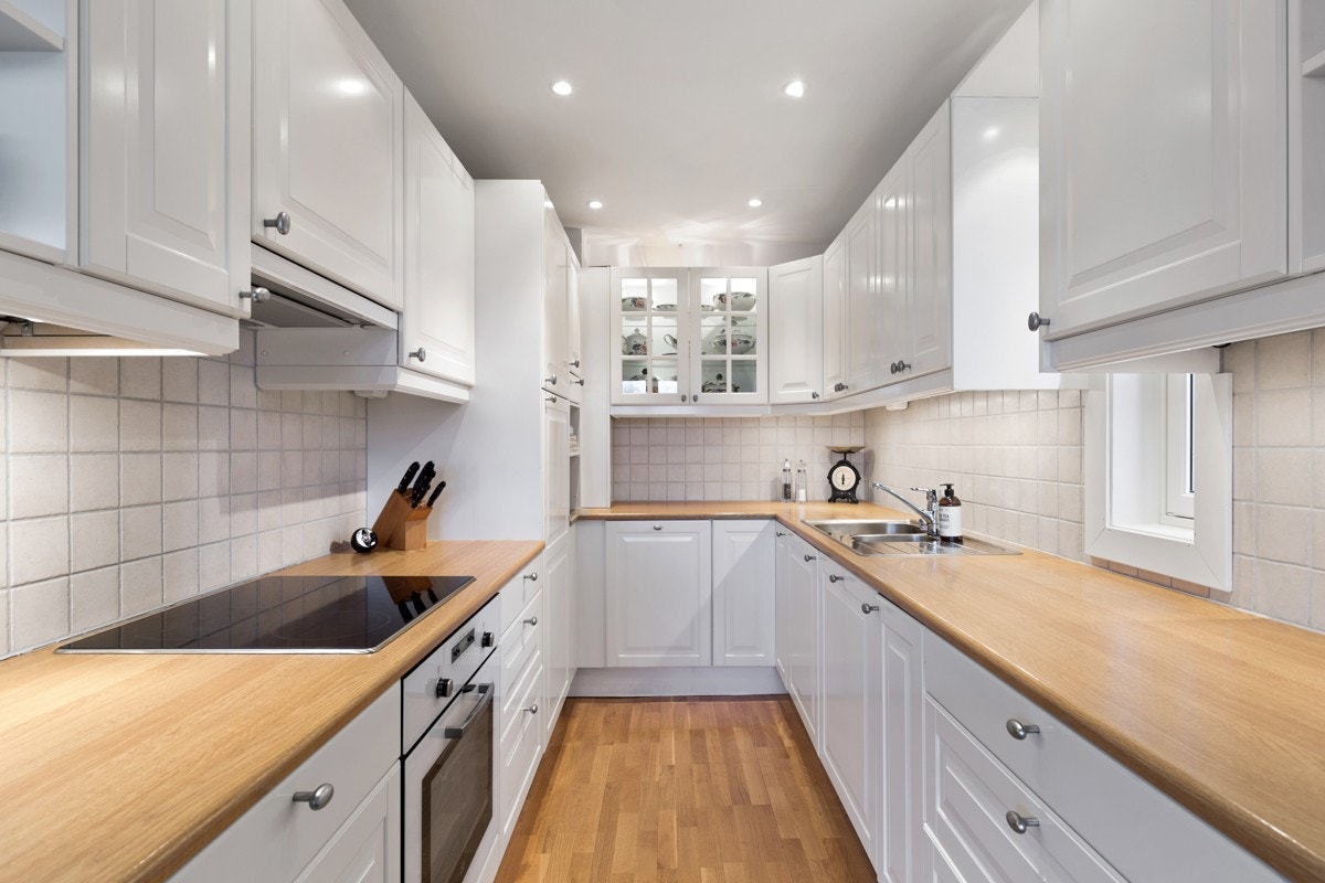 Kjøkkenet har integrert hvitevarer som komfyr med platetopp, kjøleskap og oppvaskmaskin Galleribilde