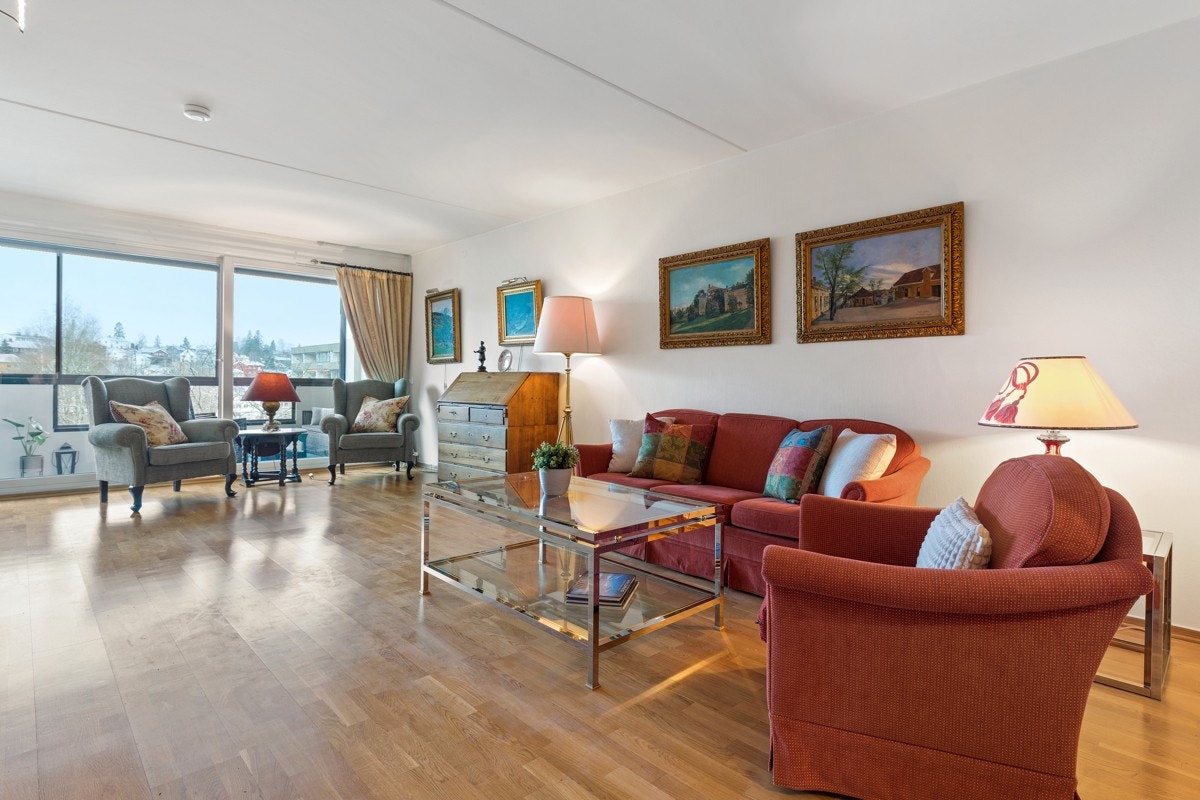 Stuen med innglasset balkong blir et naturlig sosialt midtpunkt for leiligheten Galleribilde