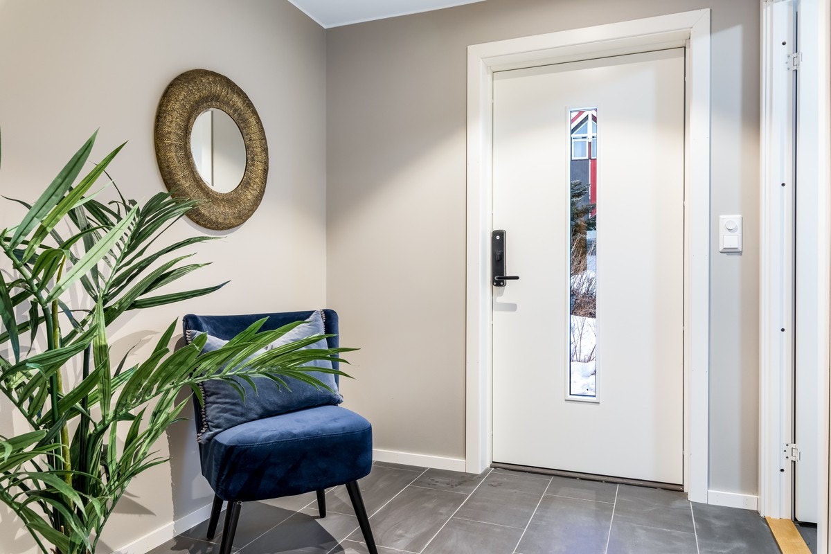 Den hvite ytterdøren har midtfelt av glass som slipper naturlig lys inn i entreen. Galleribilde