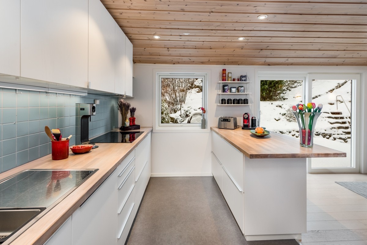 Det er etablert flis på vegg over benkeplate, belegg på gulv og downlights på panel i himling. Galleribilde