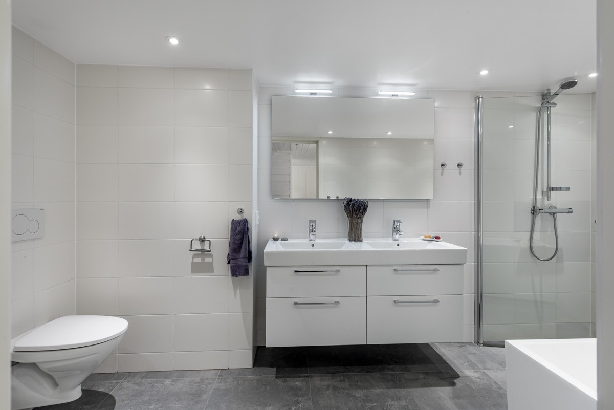 Badet er på 7.5 kvm og utstyrt med baderomsinnredning m/ dobbel servant, speil, vegghengt wc, badekar og dusjsone. Galleribilde