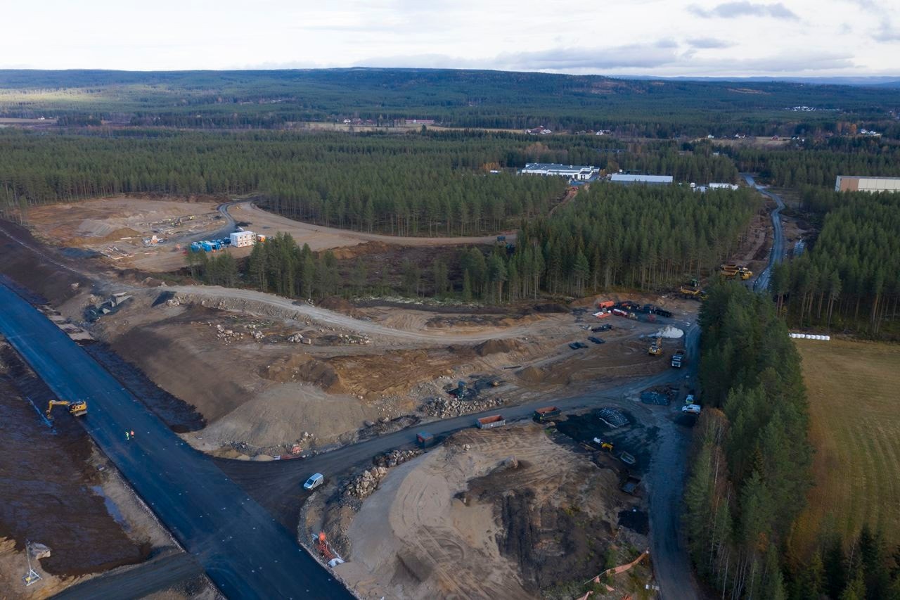 Dronebilde fra tilsvarende standpunkt som visualisering fra sørvest. Eksisterende bebyggelse i næringsparken skimtes i bakgrunnen. Galleribilde
