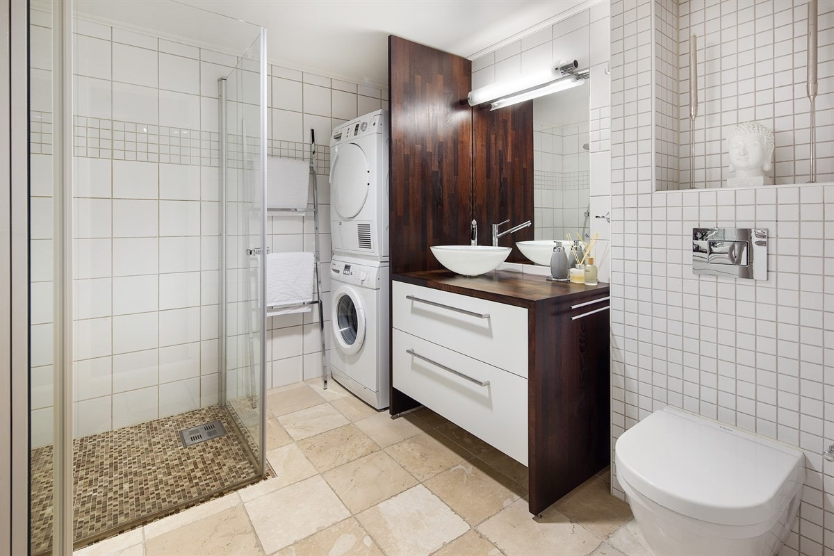 Boligen har et stilig bad som ble oppgradert med nye gulvfliser og varmekabler rundt 2012. En nisje på siden av servantinnredningen har plass for vaskesøyle. Galleribilde