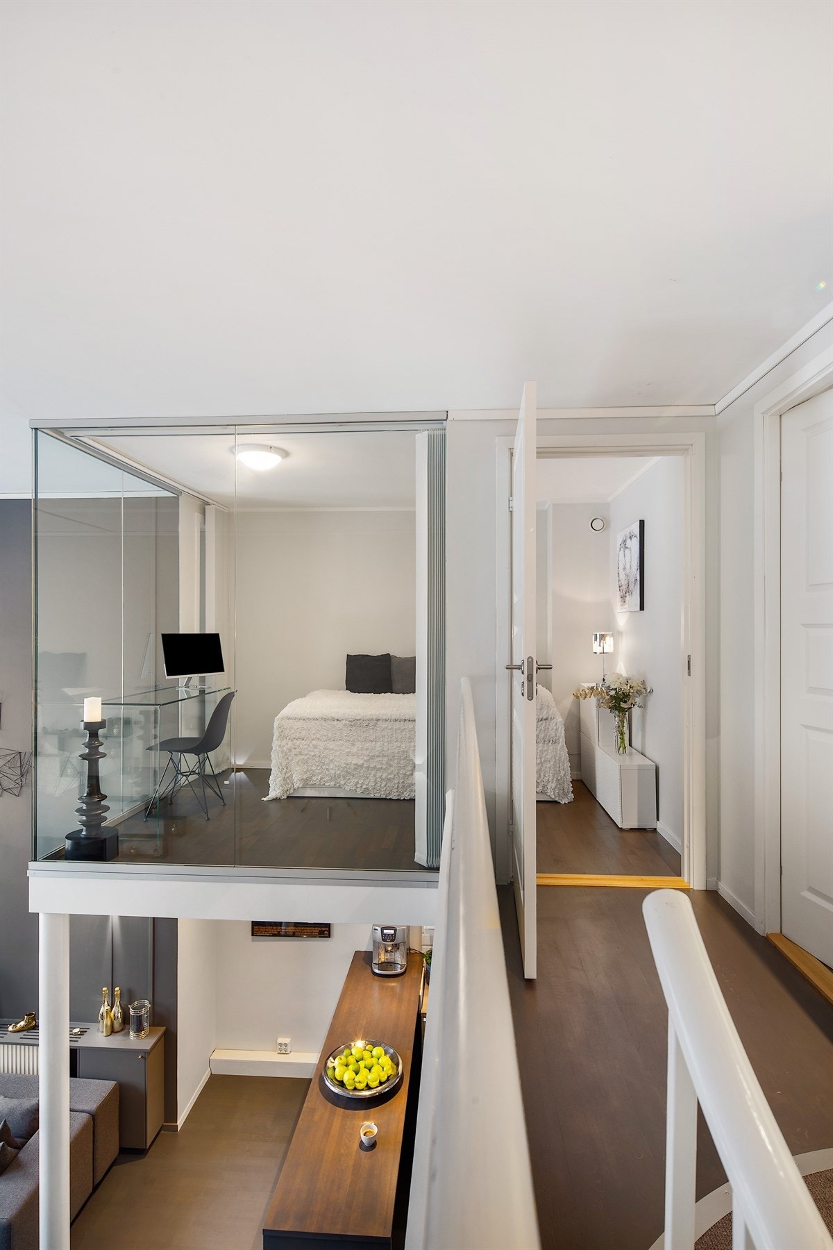 På mesaninen ligger også et lyst, luftig innredet rom med vindu som kan benyttes som gjesterom/kontor. Rommet har glassvegger mot stuen i etasjen under, og er utstyrt med lammeller som skjermer rommet når det benyttes som soverom. Galleribilde