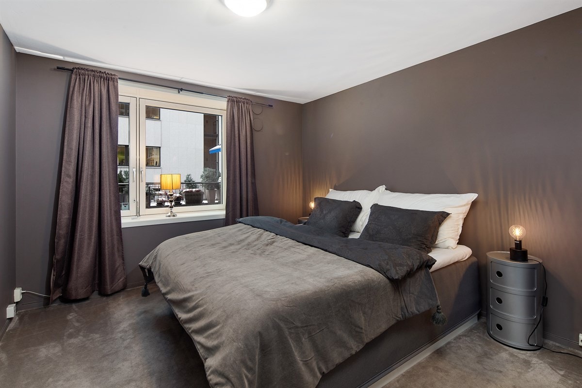 På mesaninen ligger et lunt, koselig soverom med et stort vindu og et åpent garderobeskap. Galleribilde