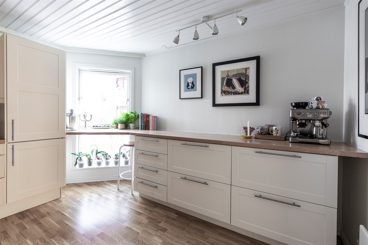 Innredning bestående av lavprofilerte fronter og vitrineskap. Benkeplate av heltre eik, fliser over kjøkkenbenk. Galleribilde