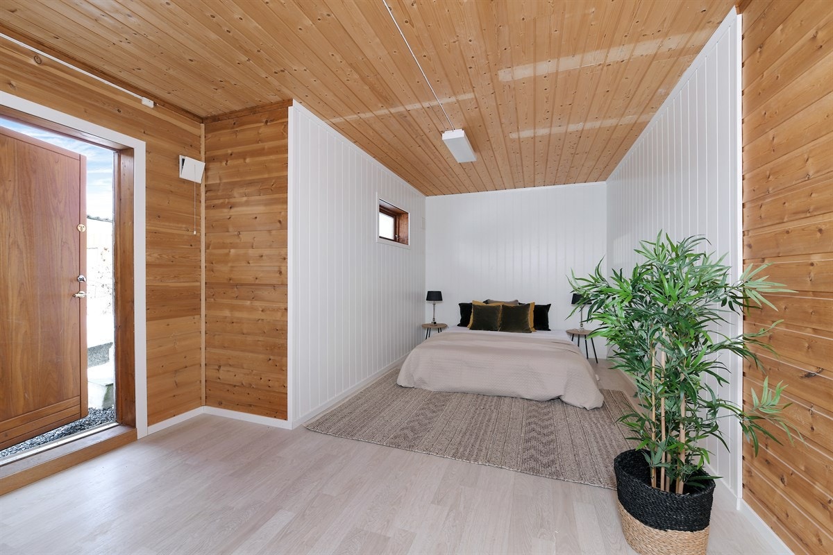 Gulvet er lagt med hvittet laminatgulv, og veggene har delvis liggende panel. Galleribilde