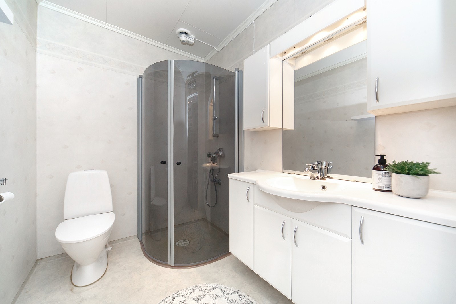 Badet er innredet med gulvbelegg og mønstret belegg på veggene. Innredningen består av servantskap med glatte fronter og to tilhørende veggskap. Galleribilde