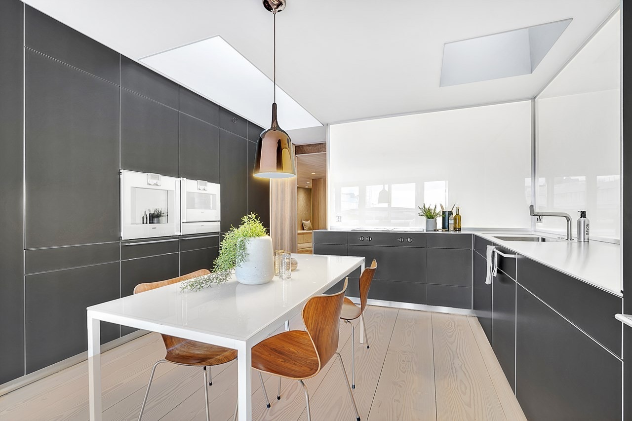 Stilrent kjøkken med kvalitetshvitevarer fra Gaggenau - stekeovn, mikrobølge ovn, komfyrtopp med keramisk topp, oppvaskmaskin samt kjøleskap. Galleribilde