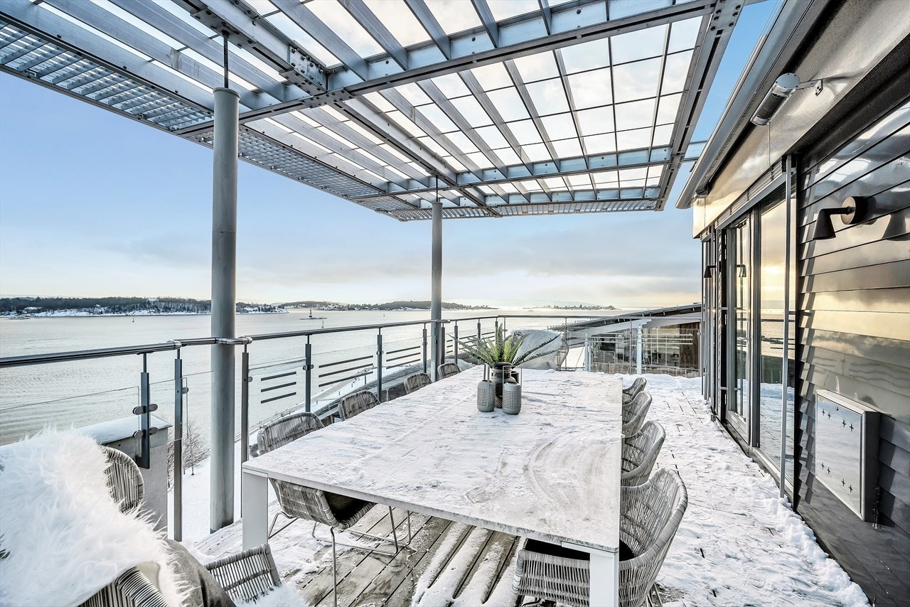 Stor terrasse mot sjøen og båthavnen som vender mot sydøst. Galleribilde